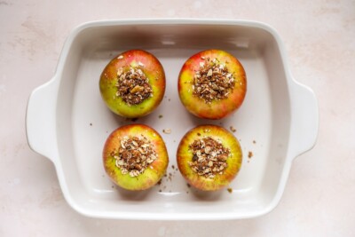 A rectangular baking dish with 4 apples filled with cinnamon oat filling.