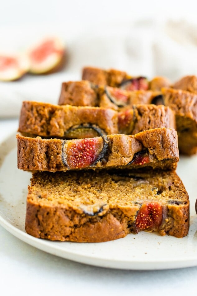 Slices of fig bread laying on top of each other on a plate, accordion style.