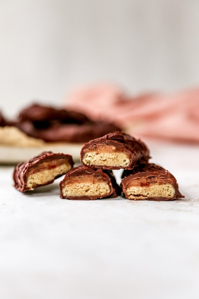 2 Healthy Twix bars cut in half, showing 4 open sides of the crispy cookie and date caramel layers.