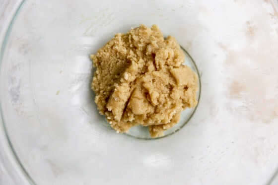 An overhead shot of the ingredients for a cookie layer all mixed together, forming a dough.