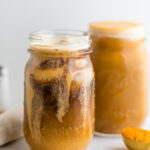 A jar of pumpkin cream cold brew with a second jar out of focus in the background.