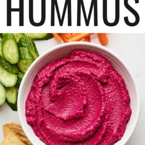 Overhead photo of a bowl of beet hummus surrounded by various veggies for dipping.