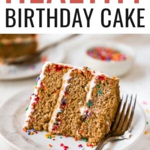 A slice of birthday cake on a plate, laying on its side.