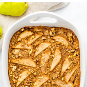 Square baking dish with pear baked oatmeal. Topped with chopped walnuts.