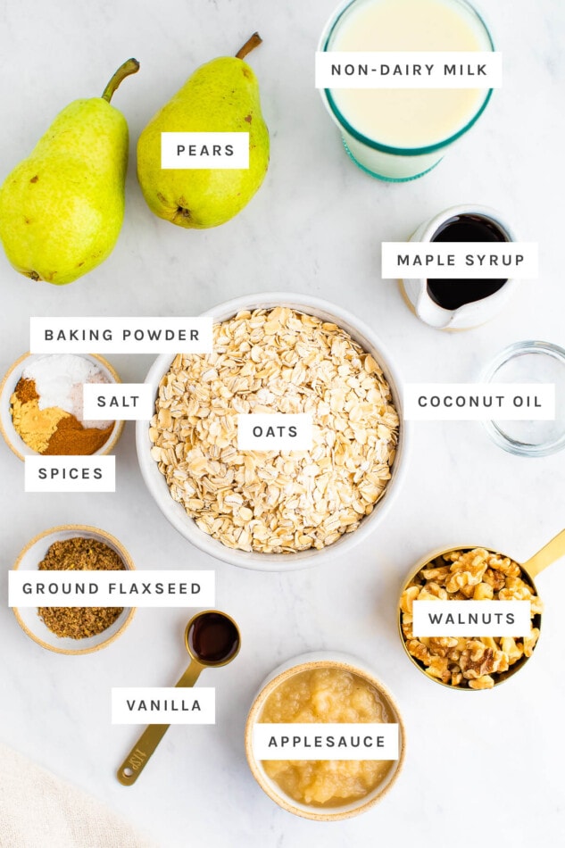 Ingredients measured out to make pear baked oatmeal: non-dairy milk, pears, maple syrup, baking powder, salt, spices, oats, coconut oil, ground flaxseed, vanilla, applesauce and walnuts.