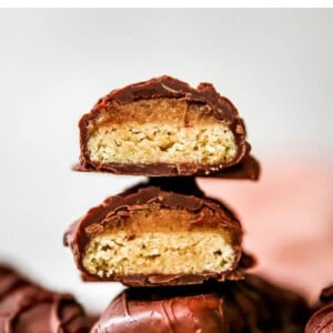Healthy Twix bars stacked on top of each other. They are cut in half and exposing the inside cookie layer.