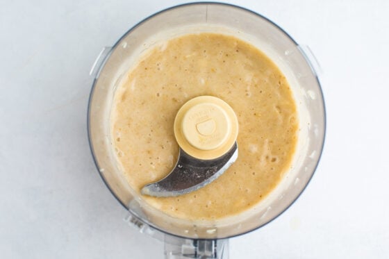 An overhead photo of bananas that have been blended into a puree in a food processor.