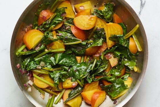 Beet greens and beets in a sauté pan.
