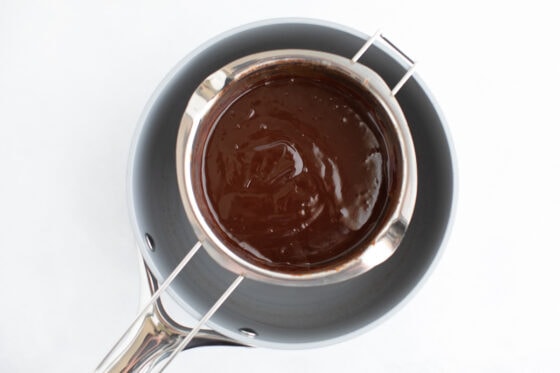An overhead photo of a double boiler with melted chocolate resting over a pot of water.