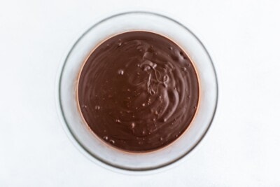 An overhead photo looking at a glass bowl with melted chocolate.