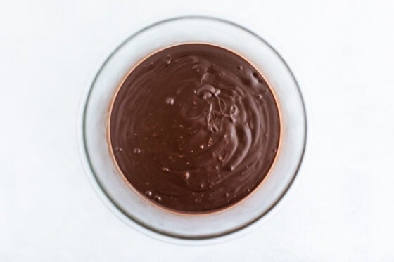 An overhead photo looking at a glass bowl with melted chocolate.