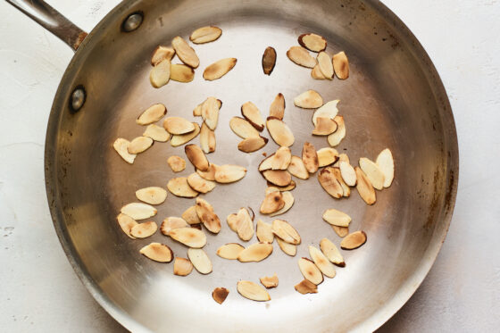 A saucepan with toasted, slivered almonds.