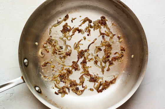 A saucepan with caramelized green onions.