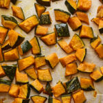 Freshly roasted Kabocha squash chunks on a sheet pan.