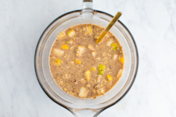 Ingredients for pear baked oatmeal all mixed together in a glass mixing bowl.