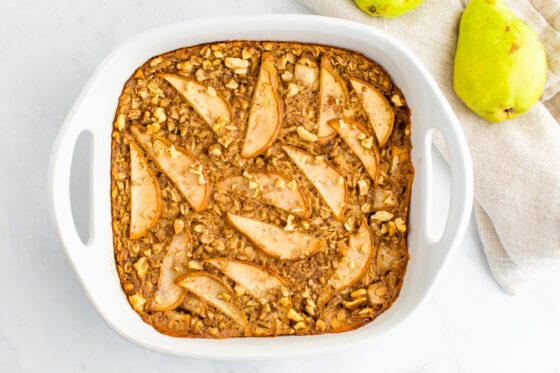 Square baking dish with pear baked oatmeal. Topped with chopped walnuts.