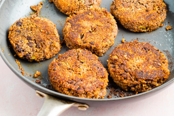 Black bean pumpkin burgers cooking on a skillet.