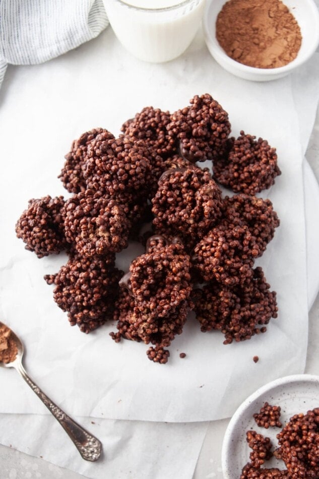 An overhead photo looking at chocolate quinoa crunch bites piled onto pieces of overlapping parchment paper.