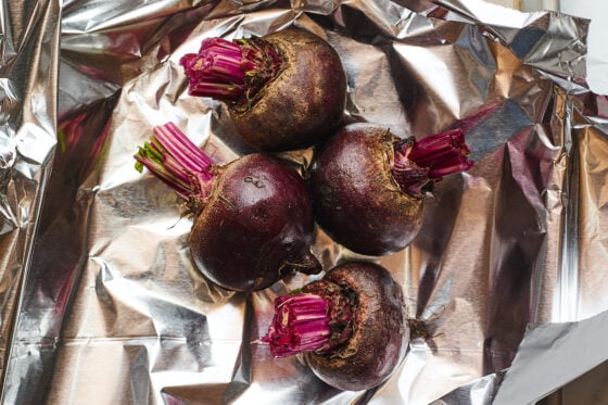 4 beet roots gathered inside of tin foil.