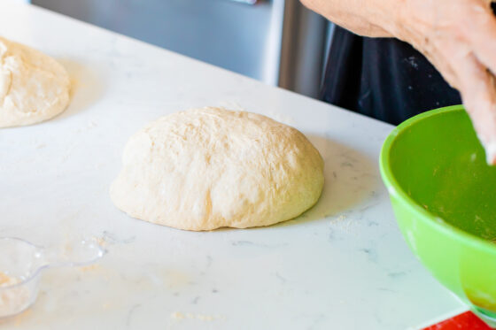 Bread dough in a mounded ball resting on a counter.