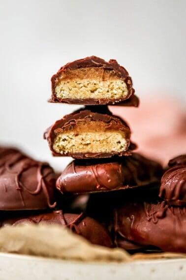 Healthy Twix bars stacked on top of each other. They are cut in half and exposing the inside cookie layer.