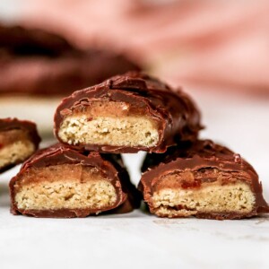 Healthy Twix bars that are cut in half exposing the insides stacked in a pyramid.