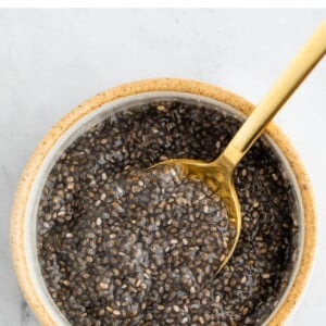 Small bowl with a chia seed egg and a gold spoon.