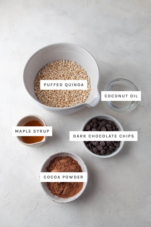 Ingredients measured out to make chocolate quinoa crunch bites: puffed quinoa, coconut oil, maple syrup, dark chocolate chips and cocoa powder.
