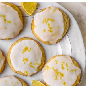 Plate of lemon cookies topped with glaze and lemon zest.