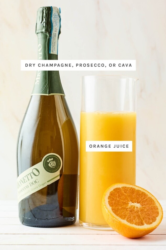 Ingredients measured out to make mimosas: a bottle of champagne and a pitcher of orange juice.