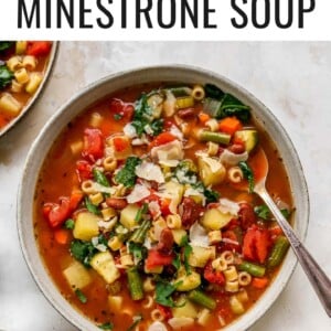 Bowl of minestrone soup with a spoon and topped with parmesan.
