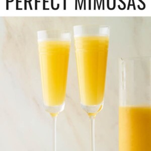 Two champagne flutes with mimosas.