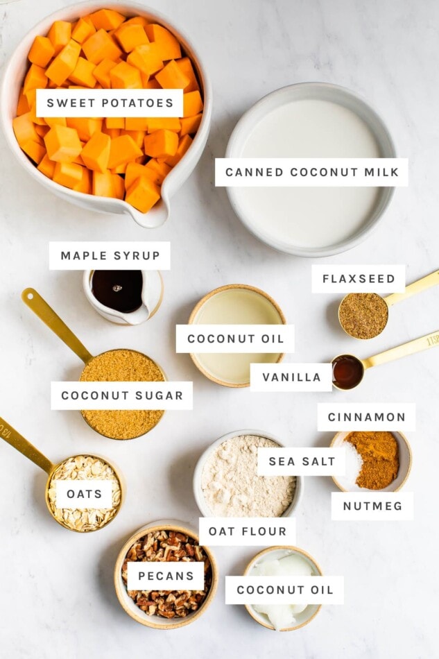 Ingredients measured out to make healthy sweet potato casserole: sweet potatoes, coconut milk, maple syrup, flaxseed, coconut oil, vanilla, coconut sugar, cinnamon, nutmeg, salt, oats, oat flour and pecans.