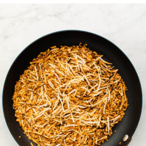 Skillet with toasted coconut flakes.