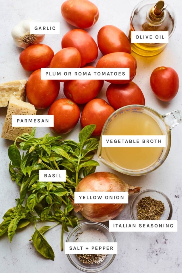Ingredients measured out to make tomato basil soup: olive oil, garlic, plum tomatoes, parmesan, vegetable broth, basil, yellow onion, Italian seasoning, salt and pepper.