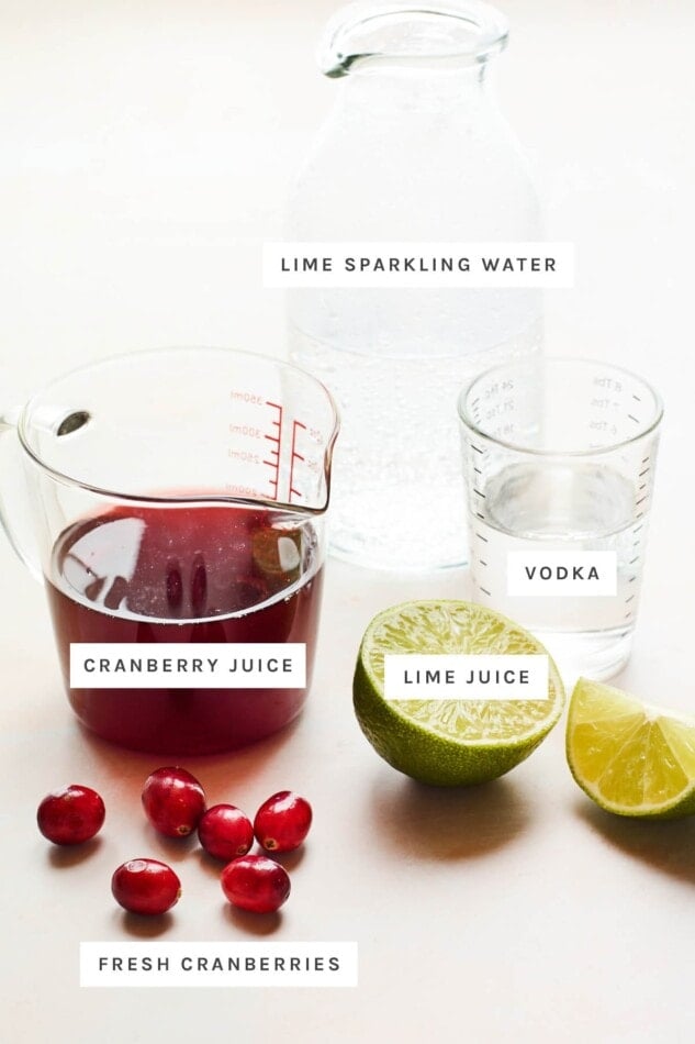 Ingredients measured out to make Sparkling Vodka Cranberry with Lime: lime sparkling water, vodka, cranberry juice, lime juice and fresh cranberries.