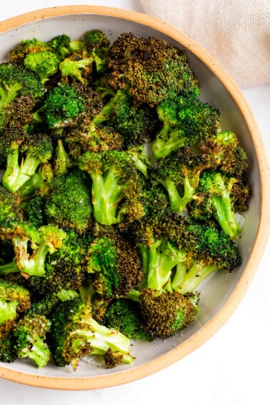 An overhead view of a bowl of air fried broccoli.