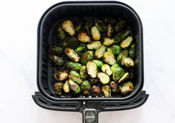 Brussels sprouts in the air fryer basket after being air fryed.