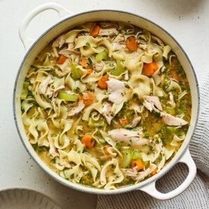 Overhead view of a dutch oven containing chicken noodle soup.