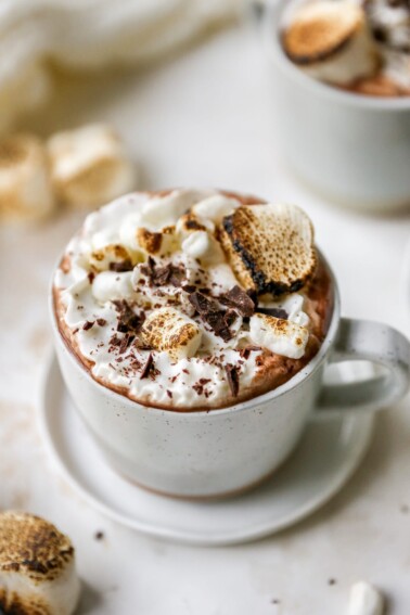 A mug of healthy hot cocoa. It has been topped with whipped cream and toasted marshmallows.