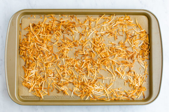 A sheet pan with toasted shredded coconut. The coconut is golden brown.