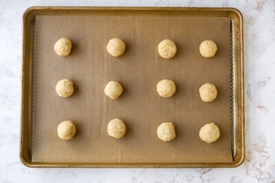 A sheet pan with lemon almond flour cookie dough, ready to be baked.