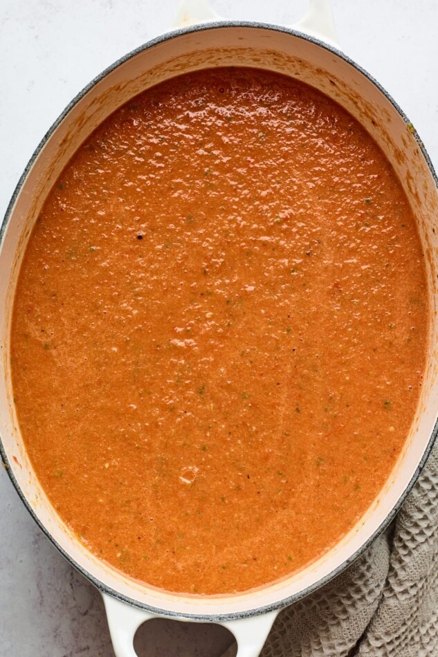 Tomato basil soup in a dutch oven after being blended with an immersion blender.