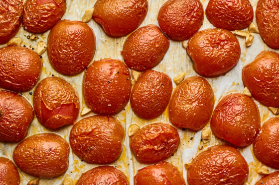Roasted tomatoes and garlic on a sheet pan.