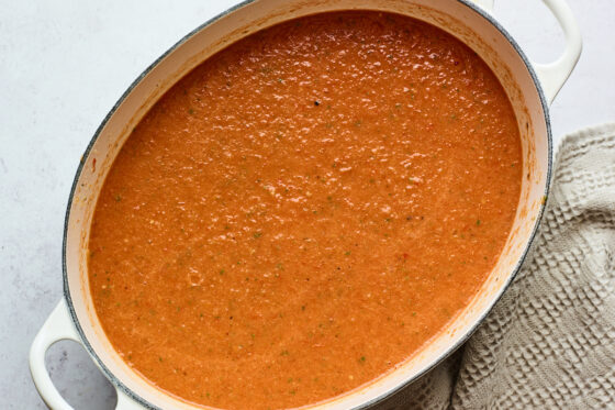 Tomato basil soup in a dutch oven after being blended with an immersion blender.