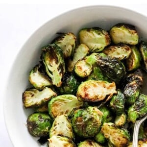 Serving bowl and spoon with crispy air fried brussels sprouts.