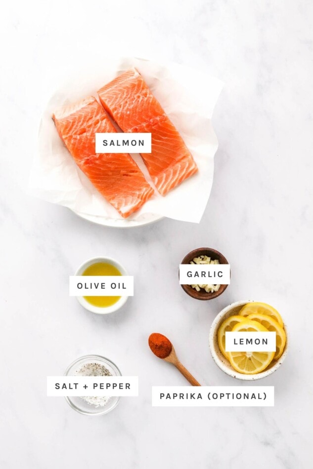 Ingredients measured out to make air fryer salmon: salmon, olive oil, garlic, salt, pepper, lemon and paprika.