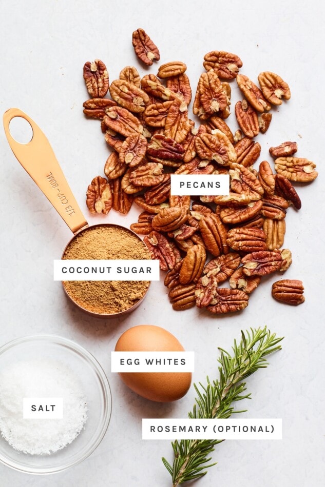 Ingredients measured out to make candied pecans: pecans, coconut sugar, egg whites, rosemary (optional) and salt.