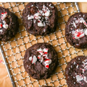 An overhead photo looking down at chocolate peppermint cookies on a wire cooling rack on top of brown parchment paper.