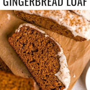 Slices of gingerbread loaf with maple cream cheese frosting on parchment paper.